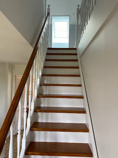 Escalier avec balustres repeints en blanc et rampe en bois