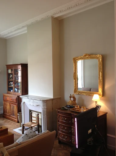 Salon ancien avec moulures, cheminée en marbre et murs gris clair